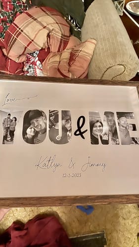 Customer's personalized 'You & Me' poster in a dark frame, featuring custom photos, names, and a date.
