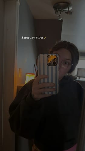 Reviewer taking a mirror selfie, showing the striped Berry Lane Blue phone case on their phone.