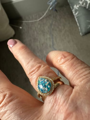 Customer's hand wearing the gold-plated Bedazzled Pear Opal Ring, showing the turquoise and white crushed opal and ashes.
