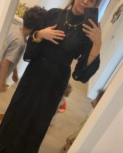Reviewer taking a mirror selfie wearing the long, black Lebsa Elise dress, showing the fit and belted waist.