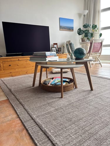 Klant toont de Hanne bijzettafel set, waarbij de tafels deels in elkaar zijn geschoven in een woonkamer.