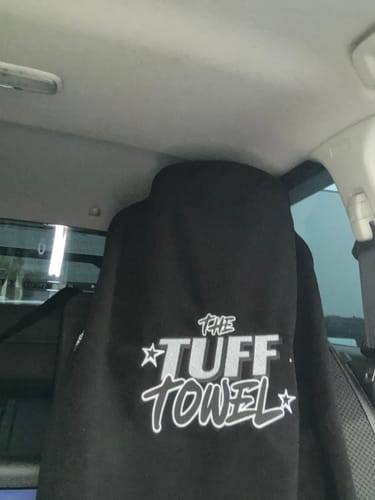 Customer's black Waterproof Car Towel Seat Cover with 'The Tuff Towel' logo draped over a car seat.
