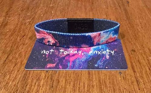 Customer's galaxy-patterned Not Today, Anxiety bracelet resting on its matching packaging card.