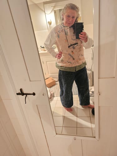 Reviewer wearing the floral print warm vest coat layered over a white shirt in a mirror selfie.