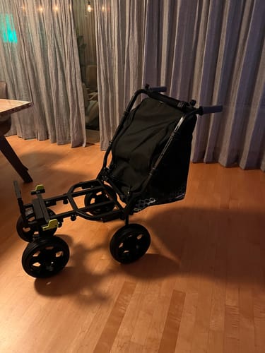 Beoordelaar toont de gemonteerde COMPACT 4 WHEEL TRANSPORTER op een houten vloer.