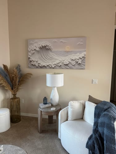 Customer's Ocean Waves Abstract Wall Art hanging in a living room above a white armchair and side table.