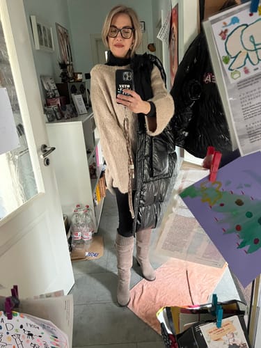 Kundin im beigen, ultra-weichen Pulloverkleid mit langen Ärmeln, getragen mit Leggings.