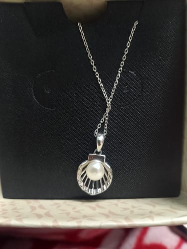 Reviewer's Silver Seashell Pearl Pendant with a thin chain shown inside its black presentation box.
