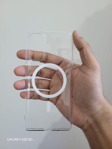 A reviewer's hand holding the transparent Anti Yellow Magsafe Clear Case for a Samsung phone.