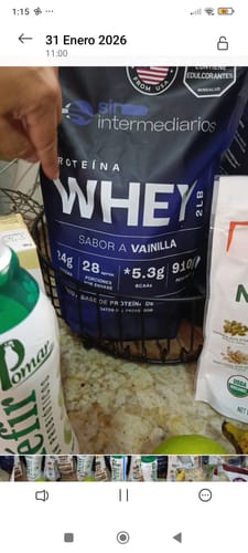 Un cliente muestra la bolsa de Proteína Whey sabor vainilla en la encimera de su cocina.