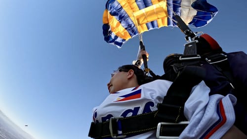 Reviewer wearing the white Philippines Heritage Custom Baseball Jersey while skydiving, with a parachute open above.