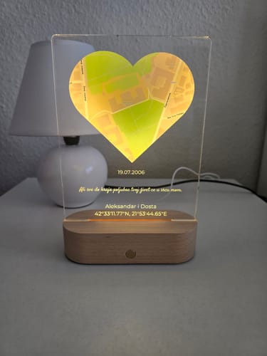 Foto eines Kunden, das das personalisierte Nachtlicht „Unser Ereignis“ beleuchtet auf einem Nachttisch neben einer Lampe zeigt.