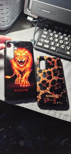 Customer shows two custom Galaxy S25 FE cases, one with a fiery lion design and one with a glittery leopard print.