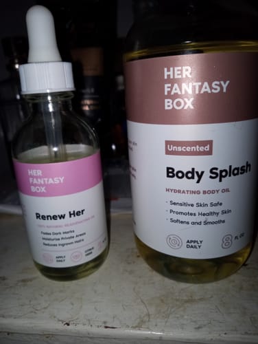 Reviewer's Unscented Body Splash hydrating body oil bottle next to another skincare product.