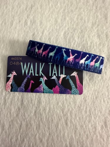 Customer's Walk Tall Bracelet with a colorful giraffe pattern, shown with its matching collector card.