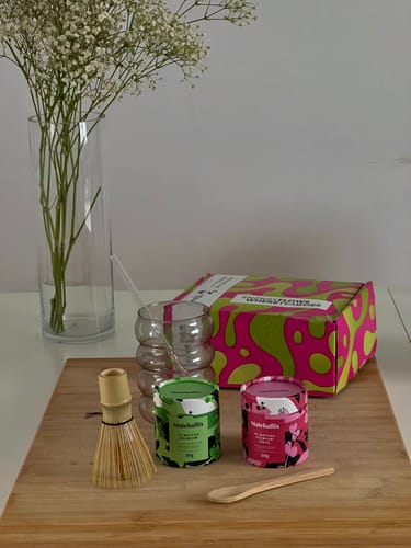 Cliente muestra el Pack Experiencia Iniciación con sus utensilios de bambú y coloridos botes sobre una tabla.