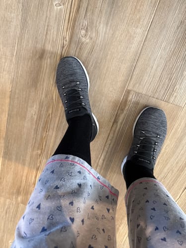 Customer wearing the black Performance Eucalyptus Compression Socks with grey sneakers and pajama pants.