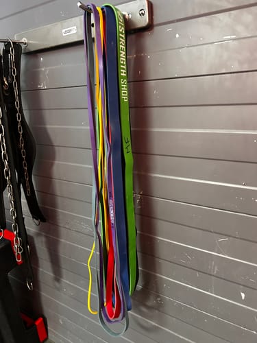 Customer's set of colorful Premium Latex Resistance Bands hanging together on a wall hook.