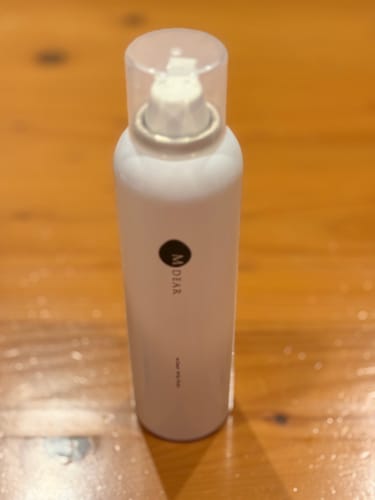 木目調のテーブルの上に置かれた、レビューアーのエムディア ホイップウォッシュのボトル。