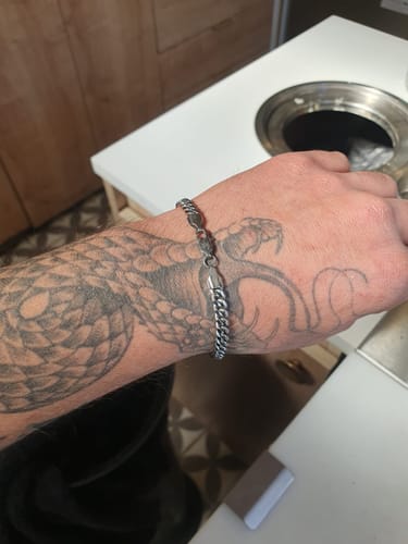 Cliente mostrando la Pulsera Miami Cuban de 5mm en su muñeca tatuada.