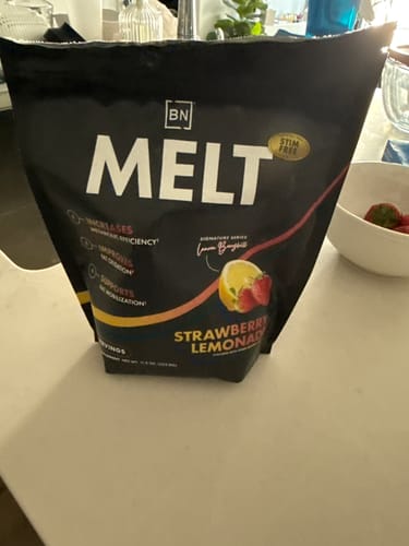 Customer's black pouch of Stim-Free Melt in the Strawberry Lemonade flavor sits on a kitchen counter.