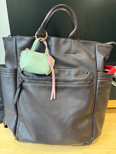 Customer's chocolate Bronx Backpack sitting on a desk, showing the front pocket and side compartments.