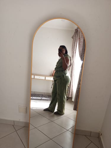 Customer's side view of the green Sleeveless Denim Cargo Hoodie Jumpsuit in a mirror.