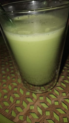 Avis du client : gros plan sur un verre de Thé Matcha Cérémonie Bio préparé, affichant une couleur verte et une texture mousseuse.