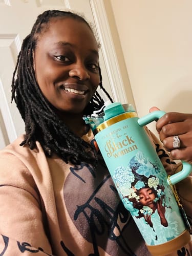 A smiling reviewer holds up the Tiffany Blue “Royalty Blossomed” Insulated Tumbler, showing the artwork.