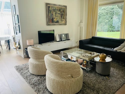 Recensent toont het witte TV-Meubel Lima in een modern ingerichte woonkamer.