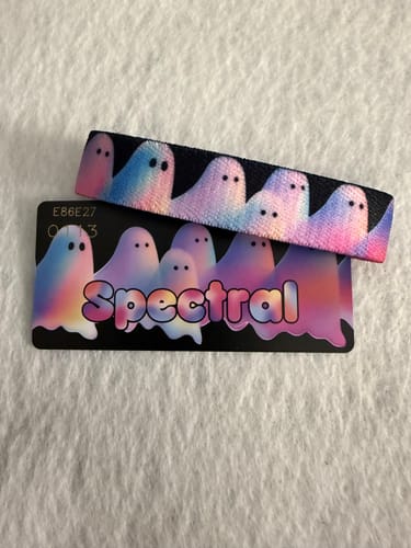 Reviewer's Spectral Bracelet and matching collector's card, both featuring a colorful ghost pattern on a white surface.