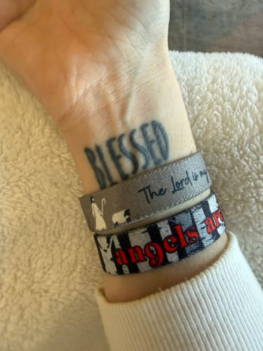 Reviewer's wrist showing the 'Angels Are Near' and 'The Lord is My Shepherd' bracelets worn together.