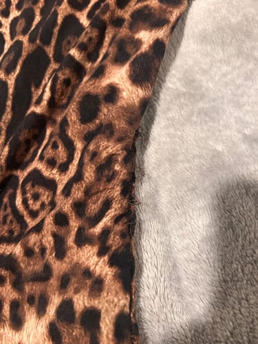 Reviewer's close-up of the Naked Print Jumpsuit showing a seam with loose, frayed threads.