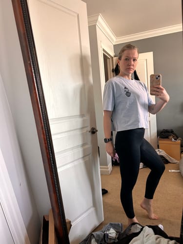 Reviewer taking a mirror selfie to show the relaxed fit of the oversized Chronically Dehydrated T-Shirt.