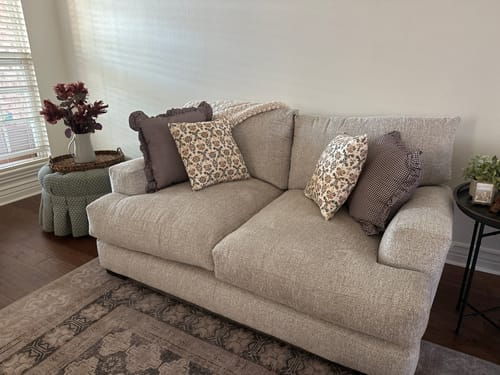 Customer's two Plum Mini Gingham Ruffle pillows styled with floral pillows on a light grey sofa.