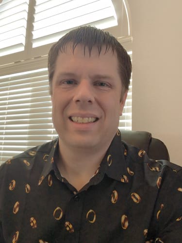 Customer smiling while wearing the black Lord of the Rings 'The One Ring' patterned shirt.