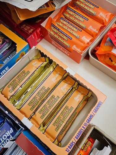 Photo d'un client montrant des boîtes de barres protéinées Barebells, avec la saveur Beurre d'Arachide au premier plan.