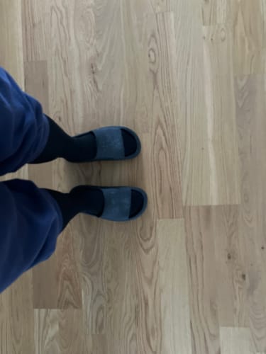 Recensentens svarta Diasocks stödstrumpor som bärs inomhus med tofflor på ett ljust trägolv.