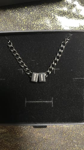Customer's personalized Legacy necklace with a dark finish, displayed inside its black presentation box.