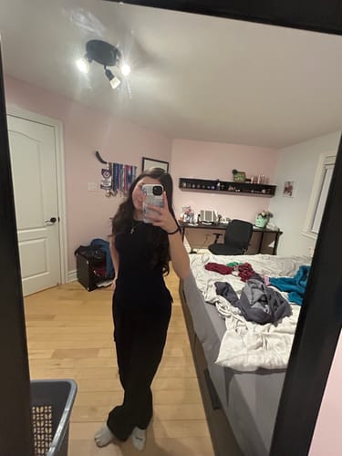 Reviewer taking a mirror selfie in their bedroom with the Coastal phone case.