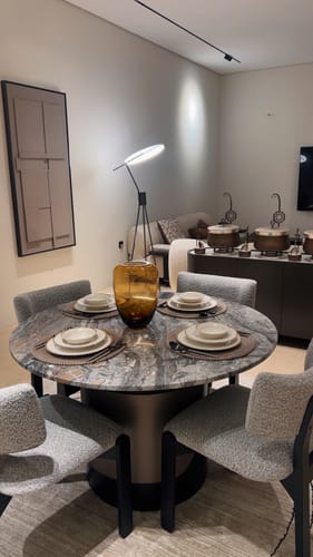 Reviewer's modern Spectra Arc Floor Lamp on its tripod base, illuminating the corner of a dining room.