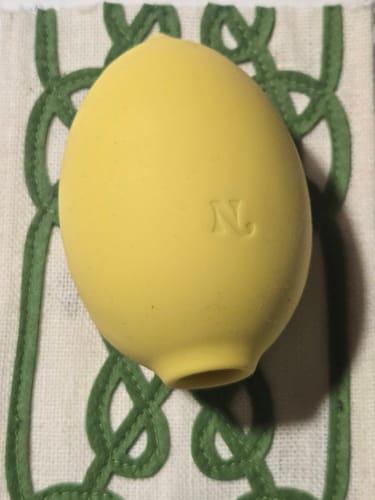 Customer's yellow, lemon-shaped Lem Clitoral Massager resting on a patterned cloth.