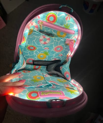 Reviewer's Loungefly Pool Day organizer brightly lit inside an open purple backpack.