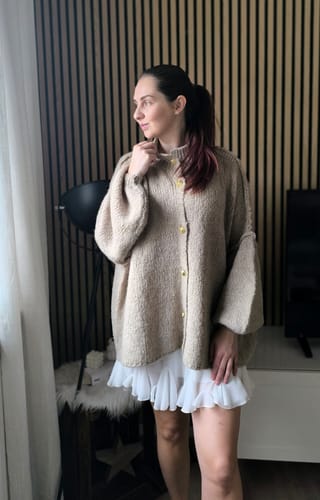 Kundin im Profil, die den weißen Rock "Summer" in Kombination mit einem Cardigan trägt.