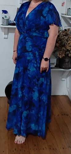 Reviewer standing indoors wearing the blue watercolour Whisper Lily Maxi Dress.