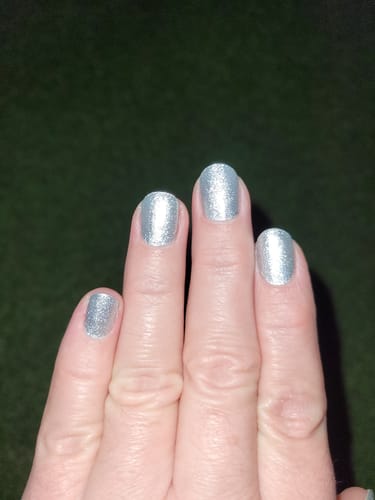 Rezensent zeigt eine Maniküre mit den silbernen, glitzernden 'Glamour Glow' UV-Gelfolien.