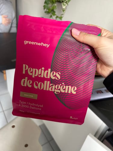 Cliente tenant le sachet rose de Peptides de Collagène saveur moccha dans sa main.