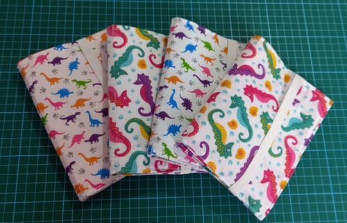 Customer's finished drawing wallets made from the colorful Seahorses Polycotton Fabric and a dinosaur print fabric.
