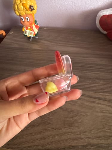 A reviewer holds the small Emmmkun Vitality Fruit Mini Toilet, showing two cute fruit figures inside the clear bowl.