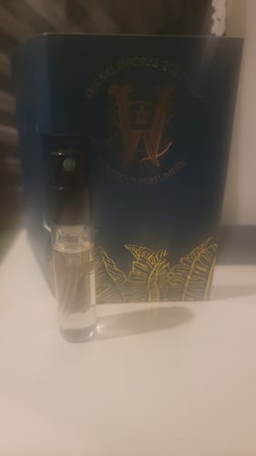 Customer's small vial of Honeyberry perfume in front of the blue and gold product packaging.